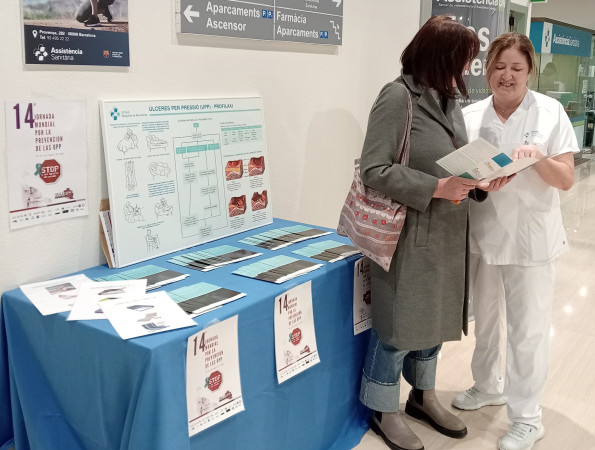Una infermera entregant un fulletó informatiu a una pacient