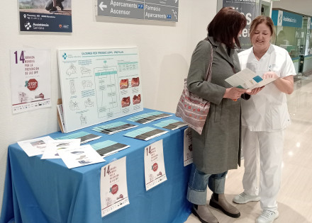 Una infermera entregant un fulletó informatiu a una pacient